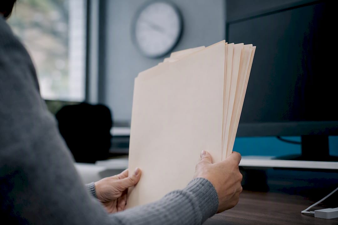 Hands holding medical credentialing files